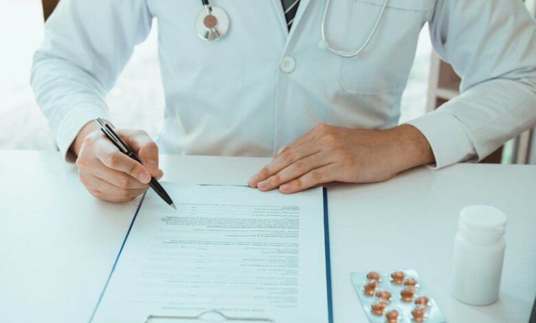 Doctor hand holding pen writing patient history list on note pad