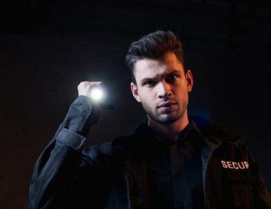 guard in uniform holding flashlight and looking at camera