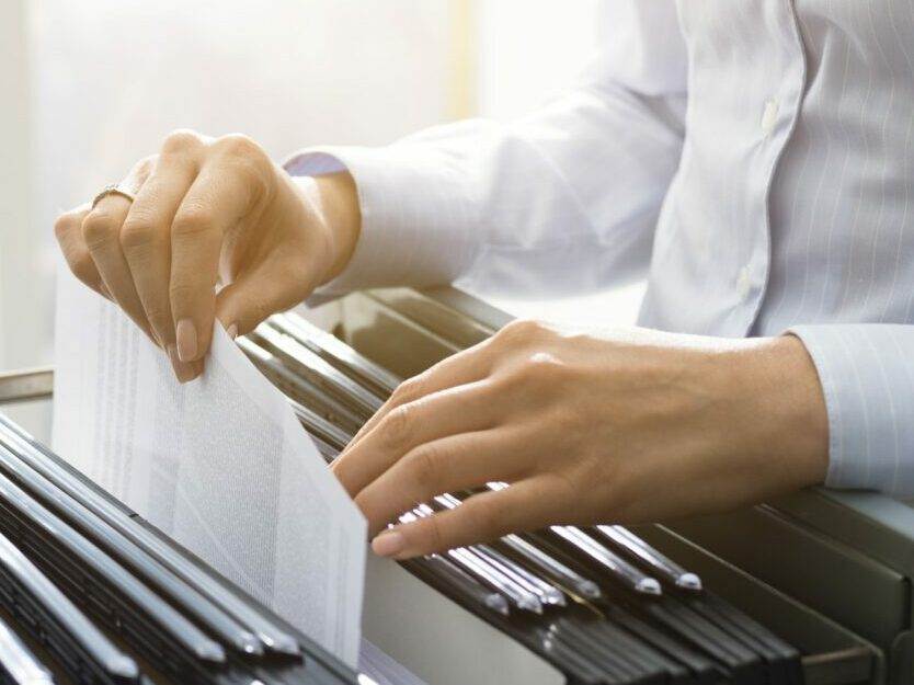 Office clerk searching files in the filing cabinet