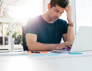 Young man using laptop and looking worried
