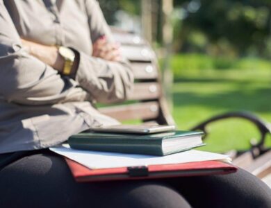 Close-up hands of business woman with notebook, papers, smartphone
