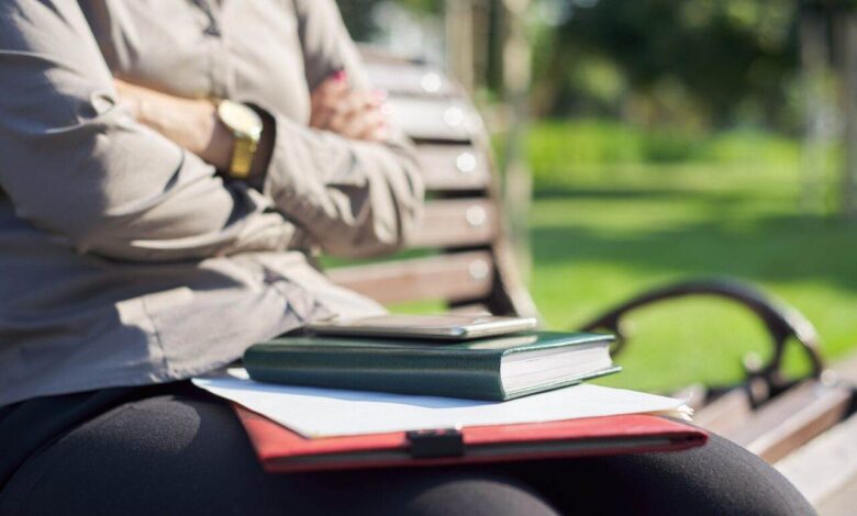 Close-up hands of business woman with notebook, papers, smartphone