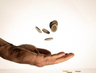 Flying money coins in the man's hand