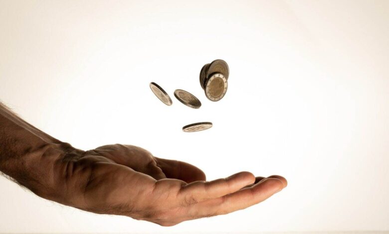 Flying money coins in the man's hand