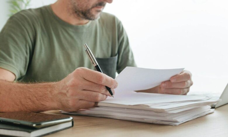 Telecommuter reading project paper document in home office