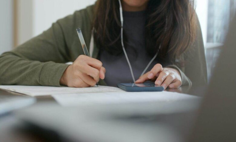 Woman do revision with cellphone at home