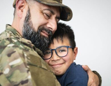 Military soldier embracing his son before leaving for the war