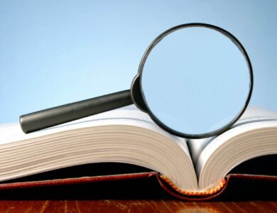 book and a magnifying glass on a blue background